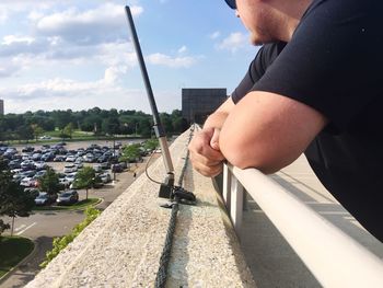 Close-up of man holding umbrella against the sky