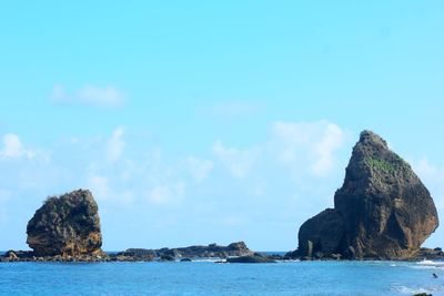 Rock formations by sea against sky