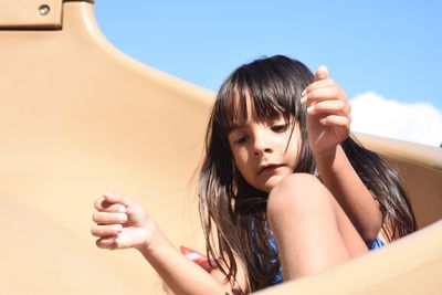 Cute girl playing on slide at playground