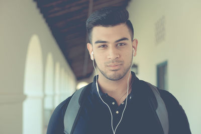 Portrait of young man listening music on earphones