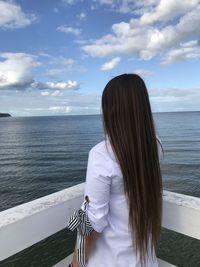 Rear view of woman looking at sea against sky