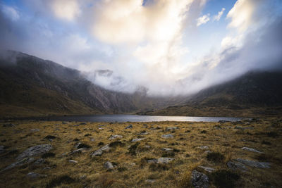 Scenic view of lake by mountains against sky