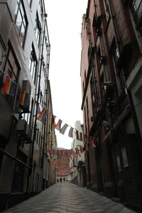 Low angle view of flags in city against clear sky