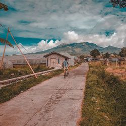 Rear view of boy riding bicycle against mountain