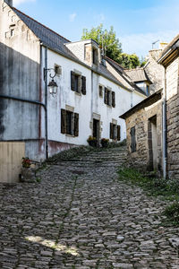 Cobblestone street amidst buildings against sky