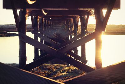 Pier over lake against sky during sunset