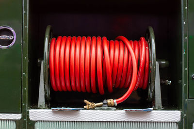  coiled or rolled red rubber fire hose seen on an old green goddess