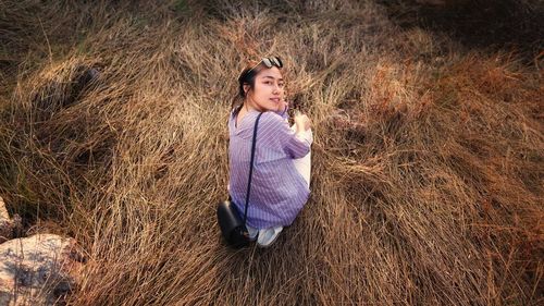 Full length portrait of woman sitting on grass