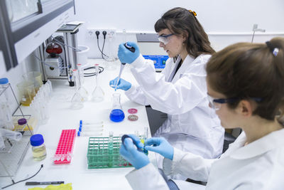 Scientists experimenting with chemicals on table in laboratory