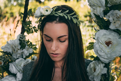 Close-up of woman amidst white flowers at park