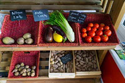 High angle view of fresh vegetables with labels on rack at supermarket