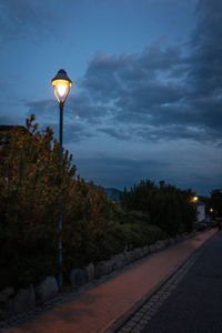 Street light by road against sky at night