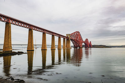 View of bridge over river against cloudy sky