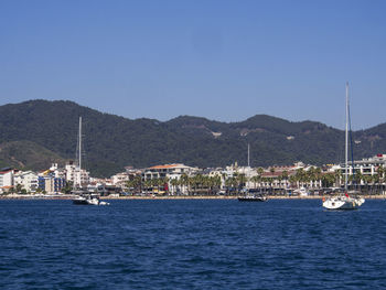 Yachts sailing on aegean sea against clear blue sky