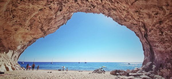 Scenic view of beach against clear blue sky