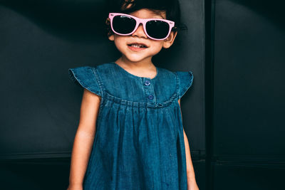 Portrait of smiling girl wearing sunglasses standing outdoors