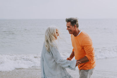 Side view of happy couple romancing at beach