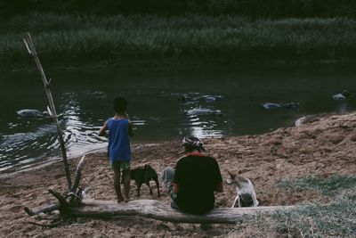 Rear view of people on shore at lake