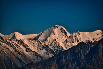 Scenic view of snowcapped mountains against clear blue sky