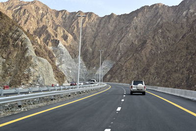 Cars on road against mountain range