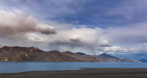 Scenic view of sea and mountains against sky