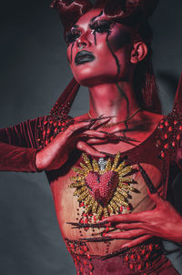 Portrait of woman standing against black background