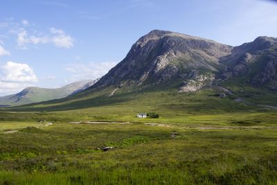 Scenic view of green mountains against sky