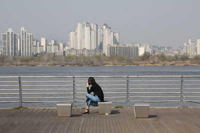 Woman sitting on promenade