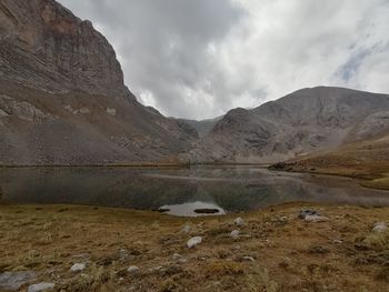 Scenic view of lake by mountains against sky