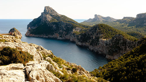 Scenic view of sea and mountains against clear sky