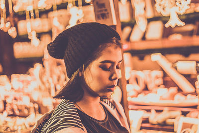 Teenage girl looking down while standing at market stall