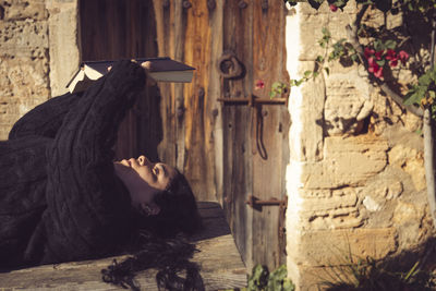 Young latin woman in the garden reading a book