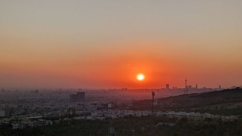 Scenic view of cityscape against romantic sky at sunset