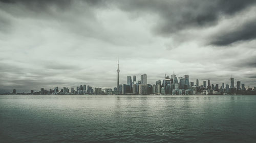 Modern buildings in city against cloudy sky