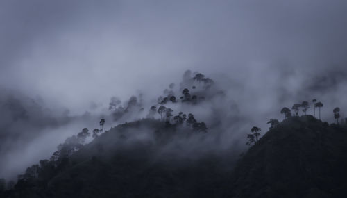 Low angle view of mountains against cloudy sky