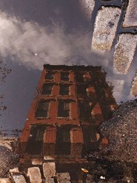 Stack of stones by water against sky