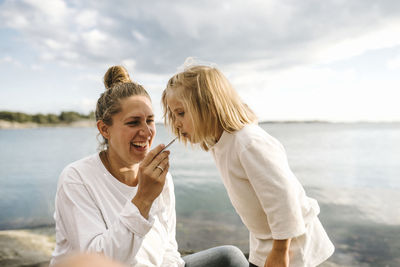 Woman smiling at beach against sky