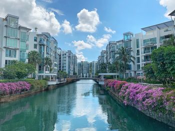 Canal amidst buildings against sky in city