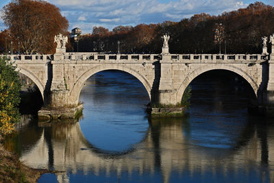 Arch bridge over river against sky