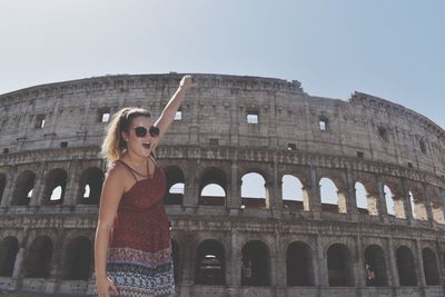 Optical illusion of happy woman holding coliseum