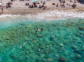 High angle view of people swimming in sea