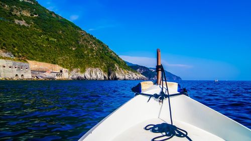 Sailboat in sea against clear blue sky