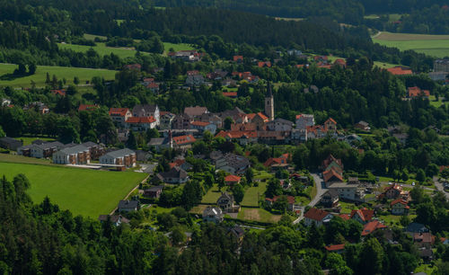 High angle view of houses amidst trees and buildings