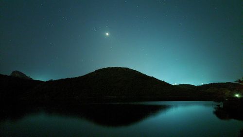 Scenic view of lake against sky at night
