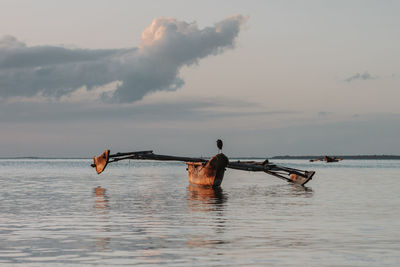 Low angle view of boat in sea against sky during sunset