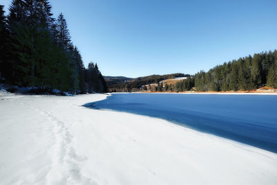 Scenic view of snow covered land against clear sky