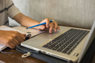 Midsection of man using laptop on table