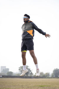 Sports and lifestyle concept- young boy jumping on the field. indian sportsman exercising.