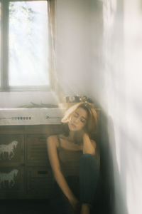 Young woman looking through window