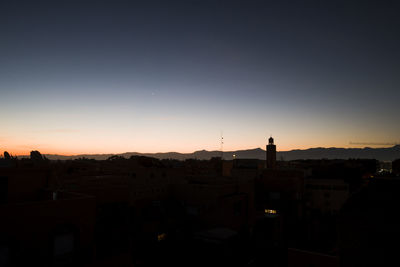 High angle view of silhouette buildings against sky during sunset